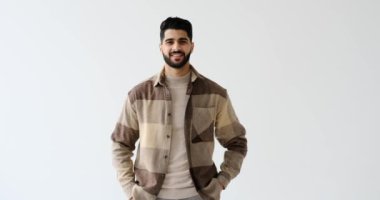 Kolları beyaz arka planda çapraz duran kendinden emin bir adam.