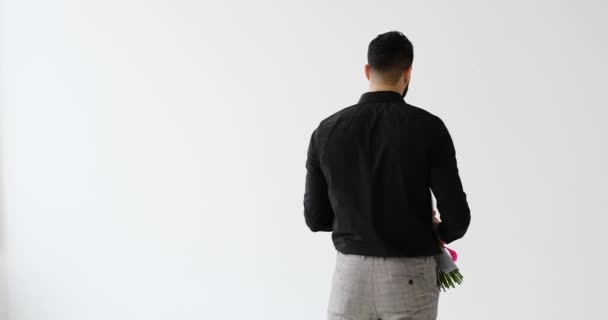 Молодий чоловік повертається і дарує букет квітів — стокове відео