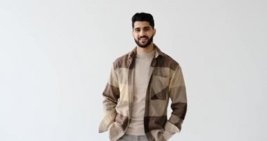 Kolları beyaz arka planda çapraz duran kendinden emin bir adam.