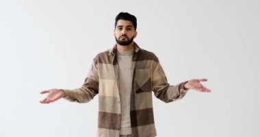 Beyaz arka planda omuzlarını silkeleyen şüpheli bir adam.