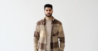 Beyaz arka planda el kol hareketi yapmayan bir adam.