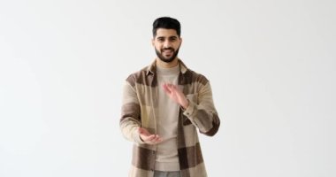 Genç adam beyaz arka planda alkışlıyor ve gülümsüyor.