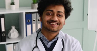 Tıp bürosunda gülümseyen genç doktor.