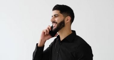 Genç işadamı beyaz arka planda cep telefonuyla konuşuyor.