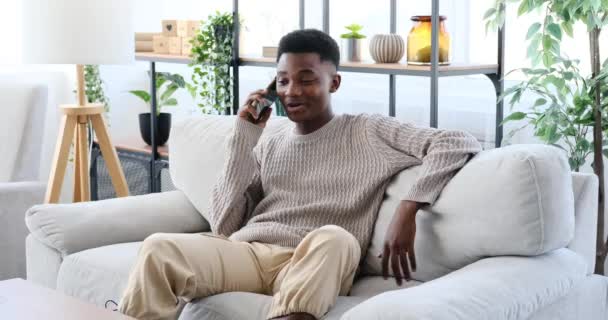 아프리카 미국인 집에서 소파에 휴대폰 통화를 — 비디오