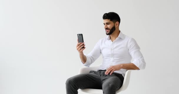 Hombre Feliz Discutiendo Videollamada Usando Teléfono Móvil Contra Fondo Blanco — Vídeo de stock