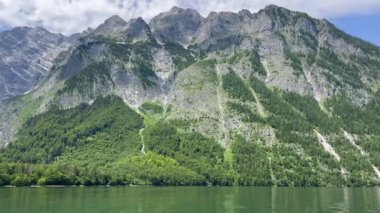 Dağlarla kaplı nehir manzarası ve gökyüzüne karşı tepe.