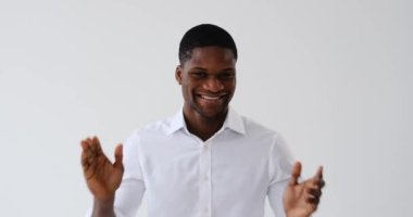 Beyaz arka planda alkışlayan ve gülümseyen Afrikalı Amerikalı iş adamı