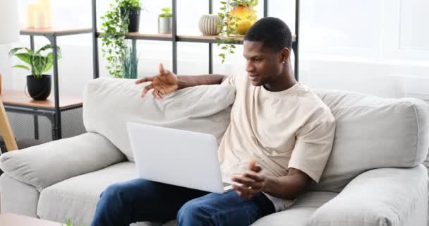 African American Man Video Chatting Using Laptop While Sitting Sofa — Vídeos de Stock