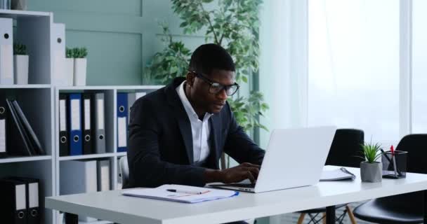 Afrikanischer Geschäftsmann Arbeitet Laptop Und Schreibt Notizen Büro — Stockvideo