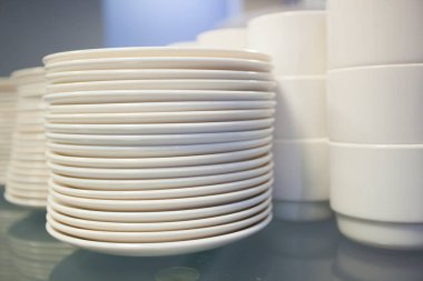 Tabakların ve beyaz fincanların ayrıntıları masanın üzerinde üst üste dizilmiş.