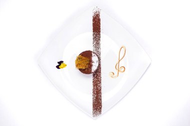 Beyaz arka planda vurulan bir restoran şefi tarafından özel bir çöl. Karamelli çikolatalı pasta.