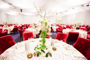 Lüks bir düğün resepsiyonunda masa. Masada güzel çiçekler var. Servis tabakları, cam bardaklar, garsonlar. Sağlık ve yaşam tarzı