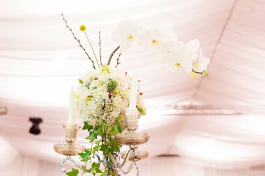 Lüks bir düğün resepsiyonunda masa. Masada güzel çiçekler var. Servis tabakları, cam bardaklar, garsonlar. Sağlık ve yaşam tarzı