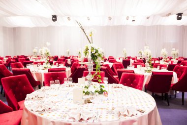 Lüks bir düğün resepsiyonunda masa. Masada güzel çiçekler var. Servis tabakları, cam bardaklar, garsonlar. Sağlık ve yaşam tarzı