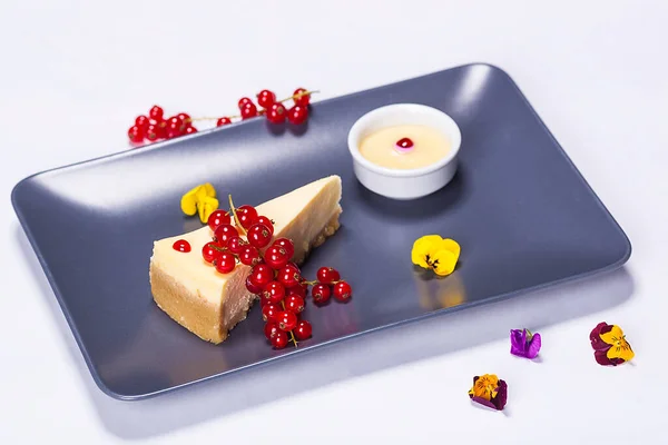 レストランのシェフが作るチーズケーキプレート 果物や異なる花で作られた組成物 ストック画像