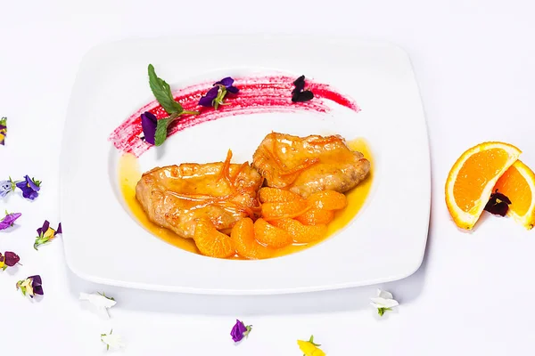 レストランのシェフによる特別料理 タンジェリン ポークチョップ 花との組成 ロイヤリティフリーのストック画像