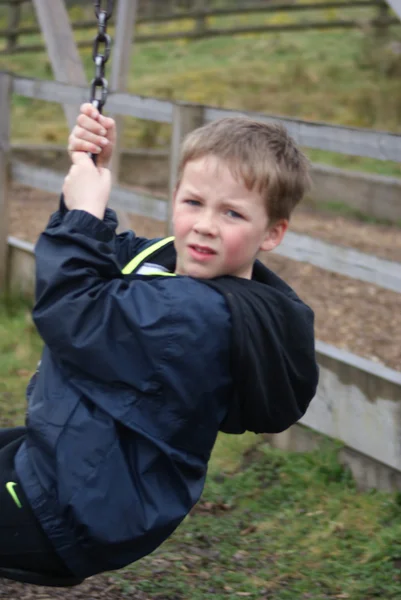 Jonge jongen swingen op zip draad — Stockfoto