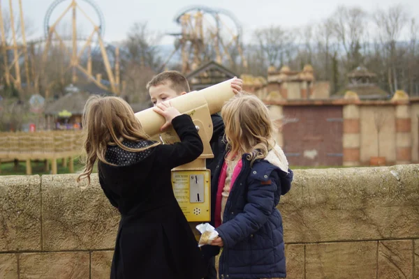 Drie kinderen ontdekken een telescoop — Stockfoto