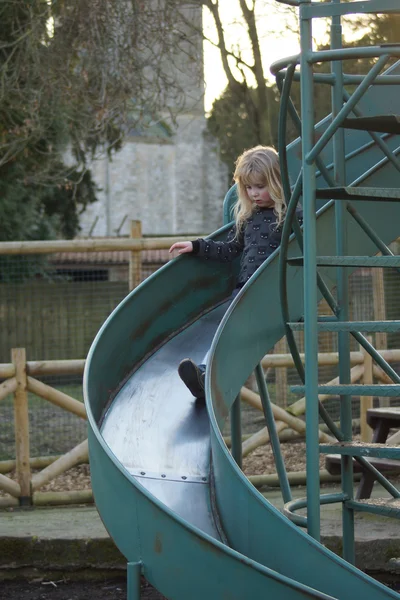 Little girl on big blue slide — Stock Photo, Image