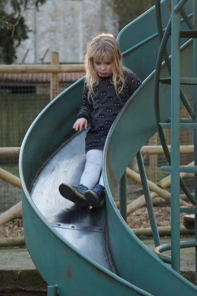 Little girl on big blue slide — Stock Photo, Image