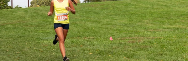 Kobieta Biegnie Dół Trawie Podczas Wyścigu Cross Country Dużą Ilością — Zdjęcie stockowe