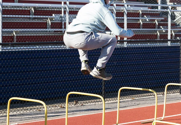 High School Boy Jumping Two Foot Tall Yellow Hurdles Front — Foto Stock