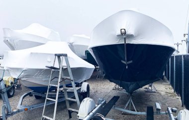 Boats on trailers wrapped up air tight and stored for the upcoming winter.