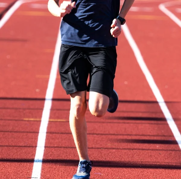 Chico Secundaria Corriendo Durante Práctica Atletismo Una Pista Roja Cerca — Foto de Stock