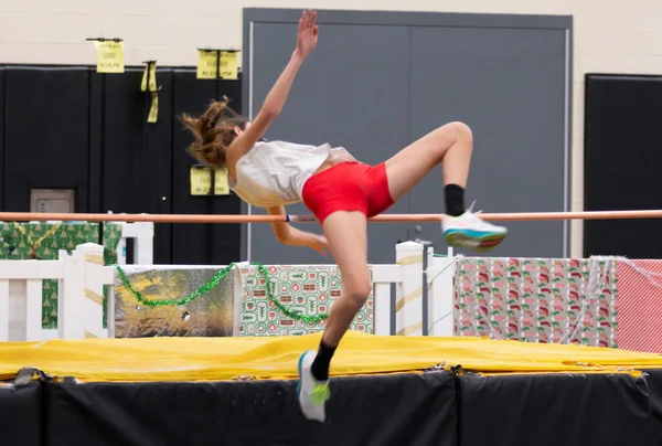 Eine Gymnasiastin Springt Bei Einem Hochsprungwettbewerb Der Halle Über Die — Stockfoto