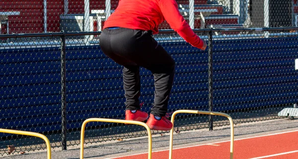 High School Athlete Jumping Plastic Hurdles Track Next Fence Front — Stock Photo, Image