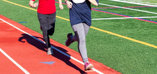 Dos Chicas Secundaria Corriendo Rápido Una Pista Durante Pista Práctica —  Fotos de Stock