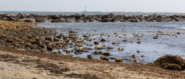 Narragansett Körfezi 'ndeki büyük kayalıklar Rhode Island' daki Roger Wheeler State Sahili 'nin yanındaki kayalık bir sahilde küçük bir koy oluşturuyor..