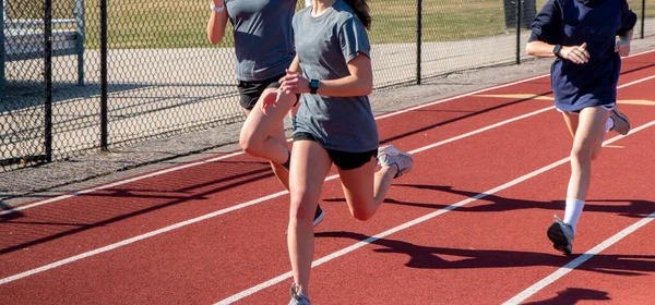 Tres Chicas Secundaria Corriendo Rápido Una Pista Roja Durante Práctica — Foto de Stock