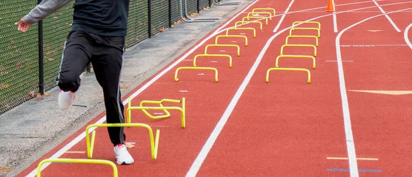 Liseli Bir Çocuk Kırmızı Pistte Spor Talimi Yaparken Sarı Plasitleri — Stok fotoğraf