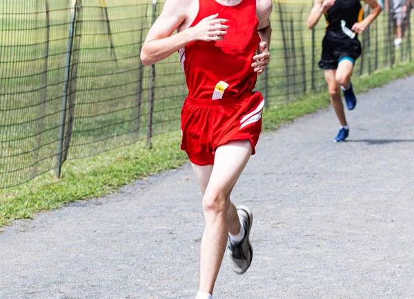 High School Boy Wearing Red Uniform Racing Gravel Path Cross — стоковое фото