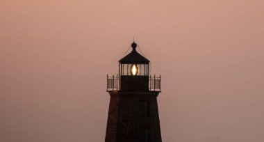 Pembe gökyüzü sabahın 4: 54 'ünde Point Judith Deniz Feneri' nin ışığıyla çok güzel görünüyor.