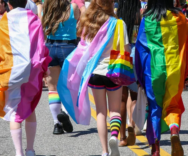 人们穿着五彩缤纷的彩虹彩旗在街头游行时的后视镜 — 图库照片