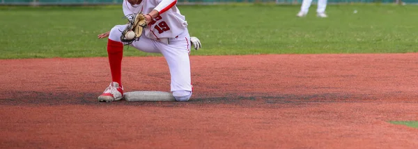 打棒球的高中棒球运动员在草地上的一场比赛中 通过把球反转到二垒的方式在场地内打球 — 图库照片