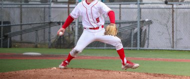 Bir beyzbol maçı sırasında lisenin beyzbol atıcısının yan görüntüsü..