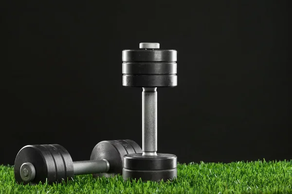 Iron dumbbell on green grass. — Stock Photo, Image