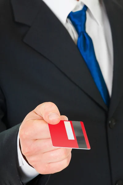 Zakenman steekt een credit card. — Stockfoto