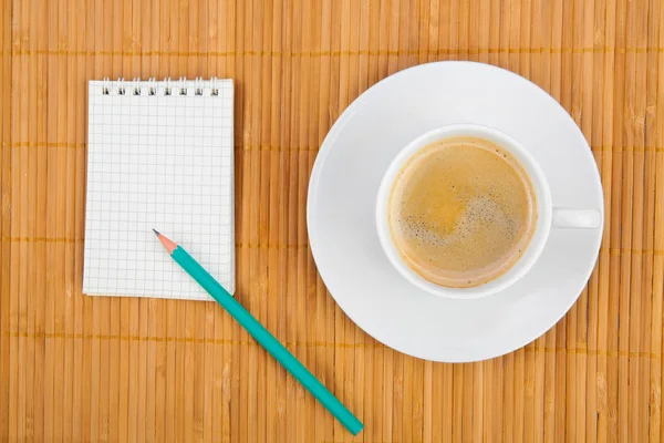 Lege notebook koffie cup op houten achtergrond — Stockfoto