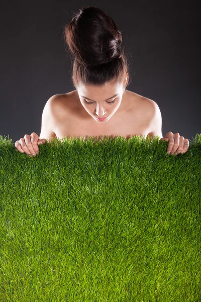 Жінка і зелена трава на темному тлі . — стокове фото