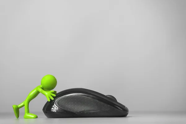 Зеленый человек толкает компьютерную мышь . — стоковое фото