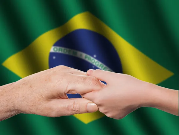 Duas mãos e bandeira brasileira — Fotografia de Stock