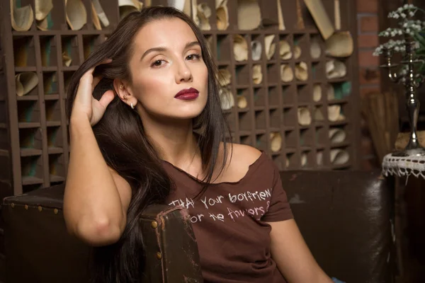 Young woman sits in an armchair — Stock Photo, Image