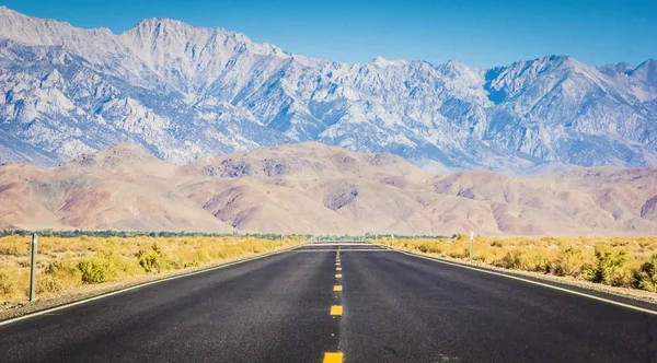 Desert highway med bergen i bakgrunden — Stockfoto