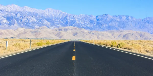 Estrada do deserto com montanhas no fundo — Fotografia de Stock