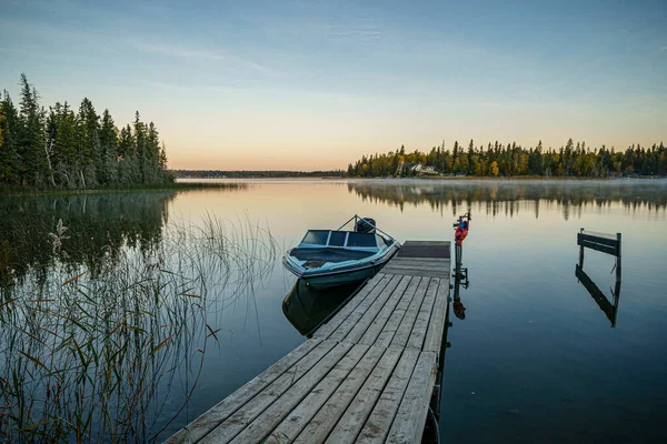 Barco en un lago tranquilo al atardecer —  Fotos de Stock